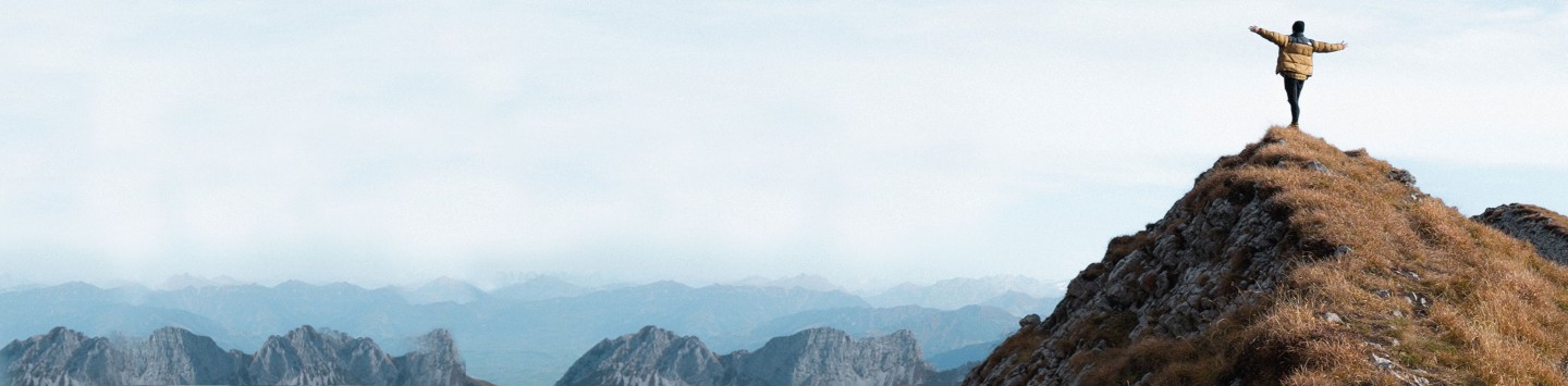 Man standing on mountain top during daytime.